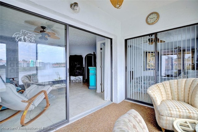 living area featuring ceiling fan and carpet flooring