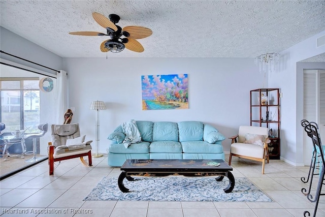 living room featuring ceiling fan, a textured ceiling, and light tile patterned floors