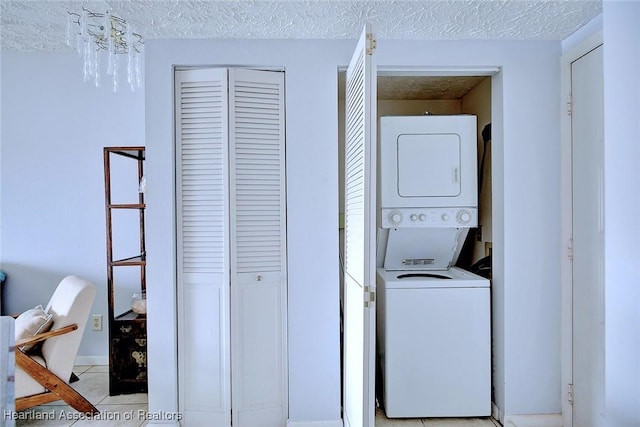 clothes washing area featuring stacked washer / dryer and a textured ceiling