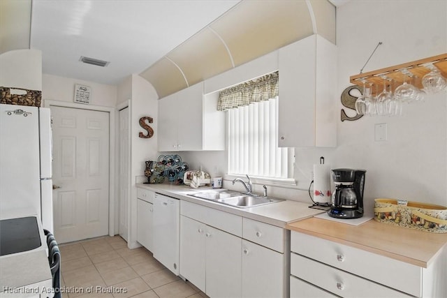 kitchen with white cabinetry, sink, white appliances, and light tile patterned floors