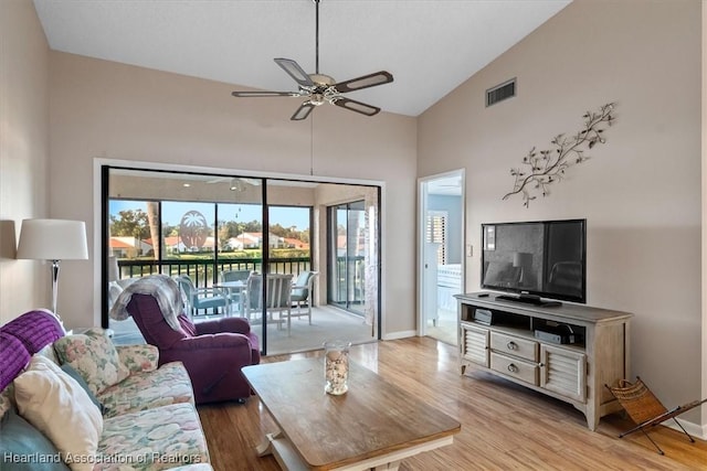 living room featuring ceiling fan, lofted ceiling, and light wood-type flooring