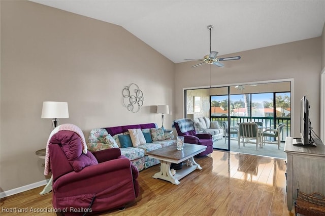 living room featuring light hardwood / wood-style floors, vaulted ceiling, and ceiling fan