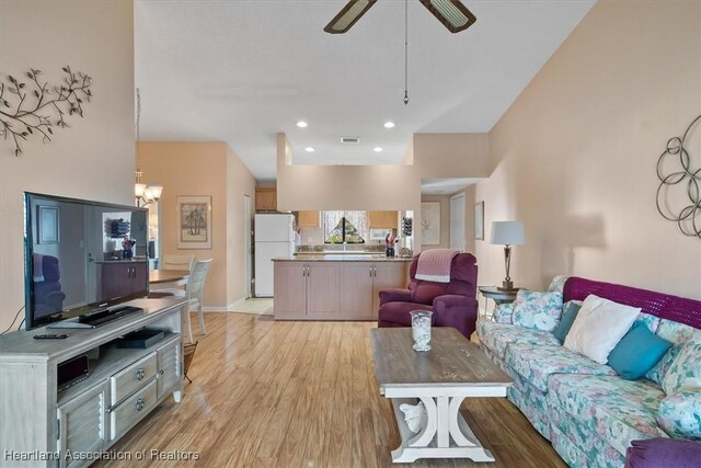 living room with ceiling fan and light hardwood / wood-style flooring