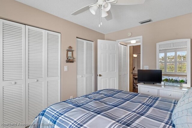 bedroom with ceiling fan and a textured ceiling