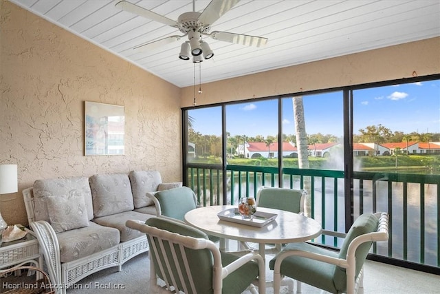 sunroom with a water view, vaulted ceiling, ceiling fan, and wood ceiling