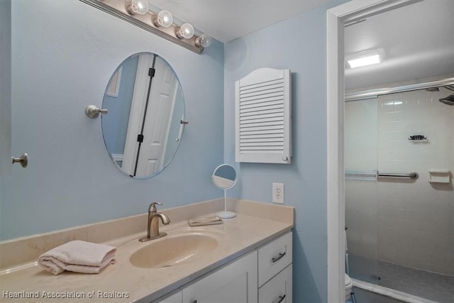 bathroom featuring vanity, toilet, and a shower with shower door