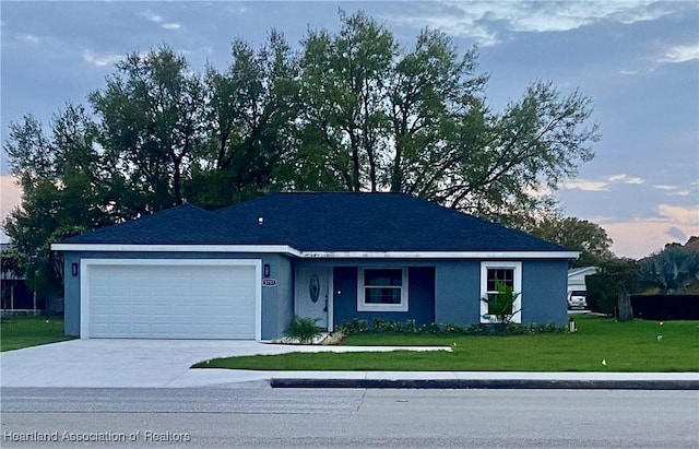 single story home featuring a garage, concrete driveway, a front yard, and stucco siding