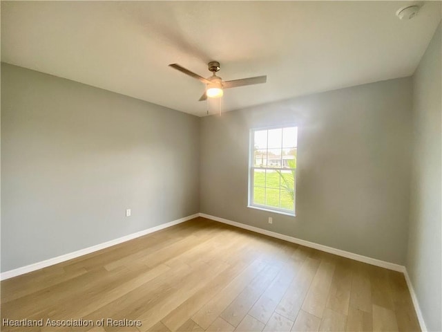 unfurnished room featuring ceiling fan, baseboards, and wood finished floors