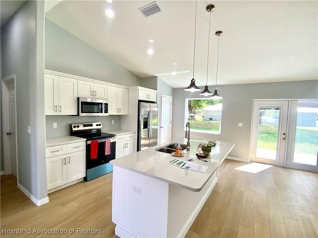 kitchen featuring a sink, stainless steel appliances, light countertops, and light wood finished floors