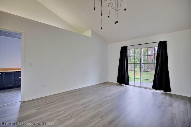 empty room featuring lofted ceiling and light hardwood / wood-style flooring