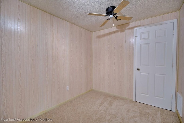 carpeted empty room featuring a textured ceiling and ceiling fan