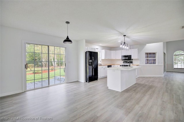 kitchen with white cabinets, pendant lighting, a kitchen island, and black appliances