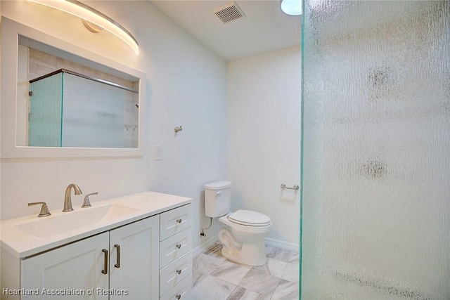 bathroom featuring vanity, toilet, and a shower with shower door