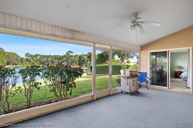 unfurnished sunroom with ceiling fan and vaulted ceiling