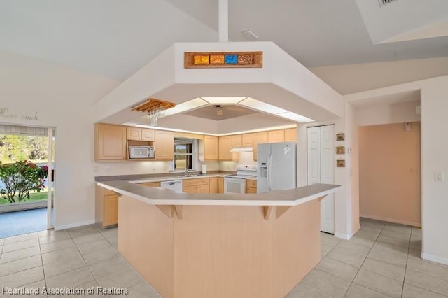 kitchen with light brown cabinetry, white appliances, a center island, and light tile patterned floors