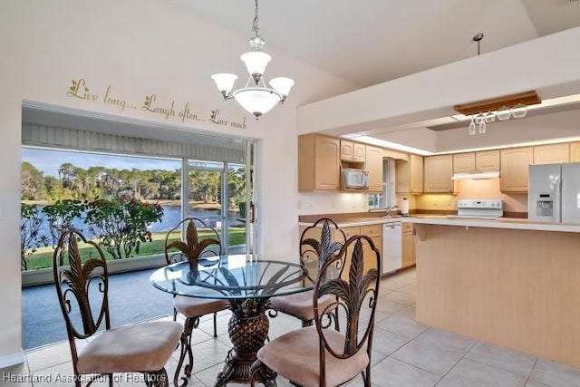 dining area featuring sink, light tile patterned flooring, a chandelier, and vaulted ceiling