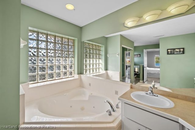 bathroom with vanity and tiled bath