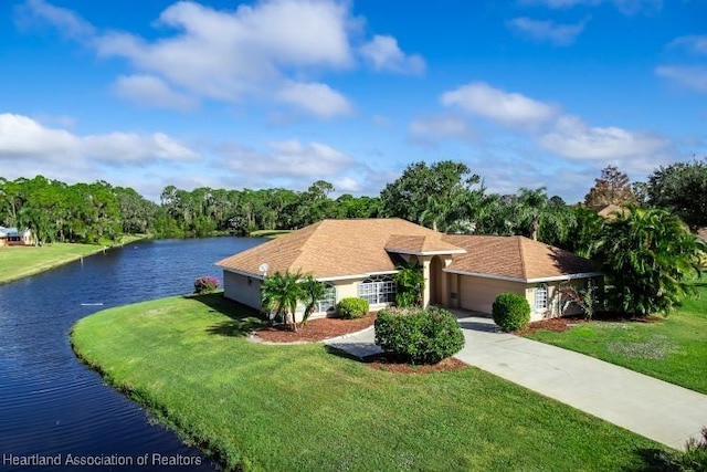 view of front of house featuring a front yard, a water view, and a garage