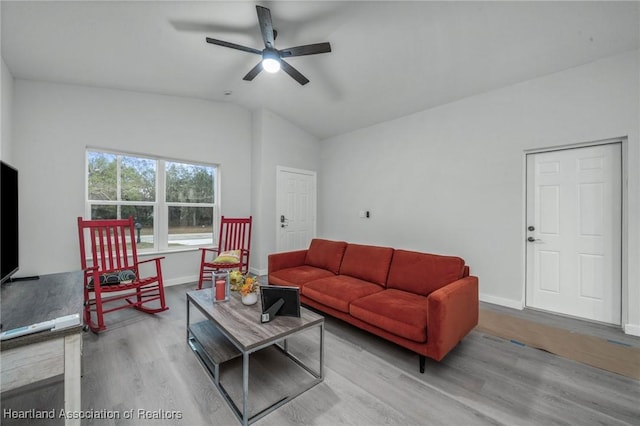 living room featuring ceiling fan, light wood-type flooring, and lofted ceiling