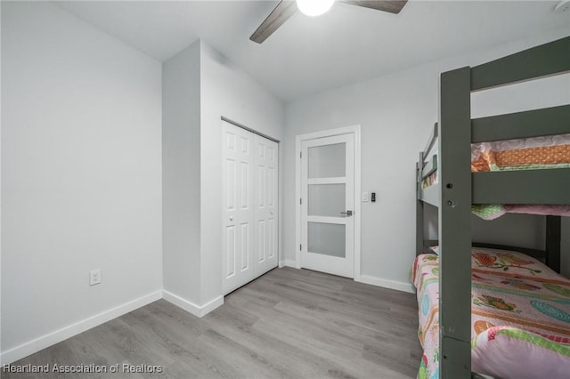 unfurnished bedroom featuring ceiling fan, a closet, and light hardwood / wood-style flooring