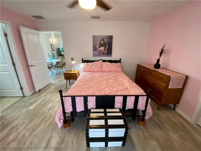 bedroom with baseboards, visible vents, ceiling fan, and wood finished floors