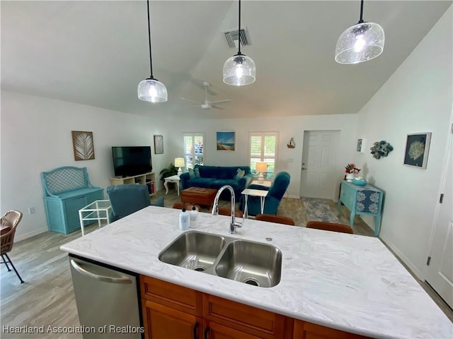 kitchen with visible vents, lofted ceiling, brown cabinets, stainless steel dishwasher, and a sink