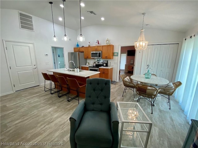 kitchen with lofted ceiling, appliances with stainless steel finishes, and visible vents