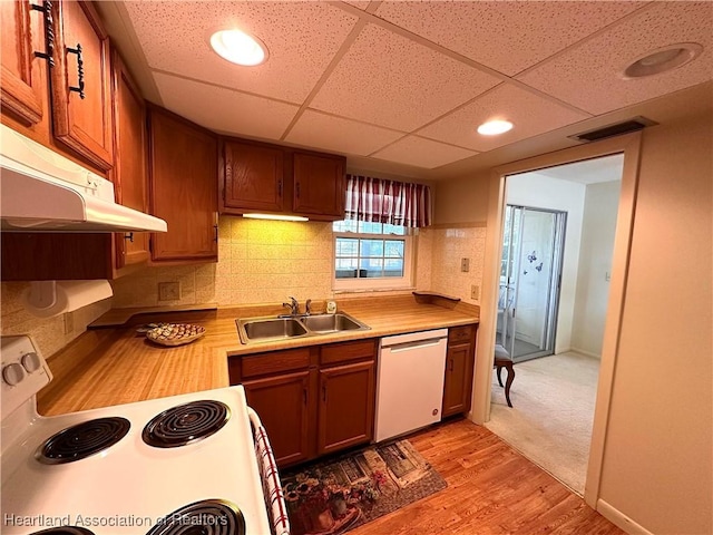 kitchen featuring a sink, white appliances, light countertops, decorative backsplash, and visible vents
