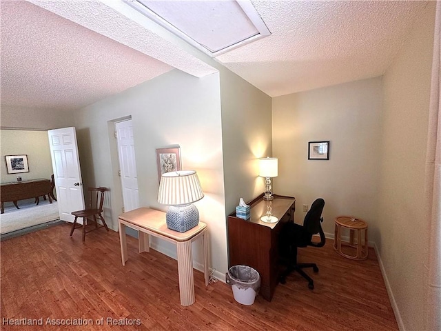 office space featuring baseboards, a textured ceiling, and wood finished floors