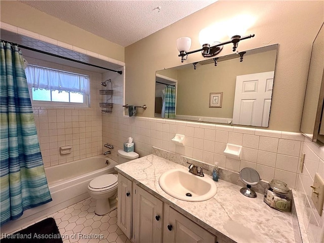 bathroom with shower / bath combo, toilet, a textured ceiling, tile patterned floors, and tile walls