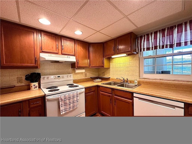 kitchen featuring a sink, light countertops, white range with electric cooktop, under cabinet range hood, and stainless steel dishwasher