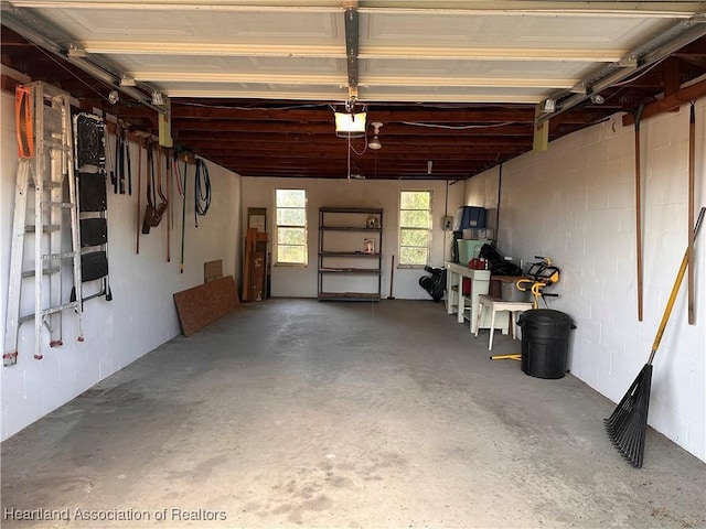 garage featuring concrete block wall and a garage door opener
