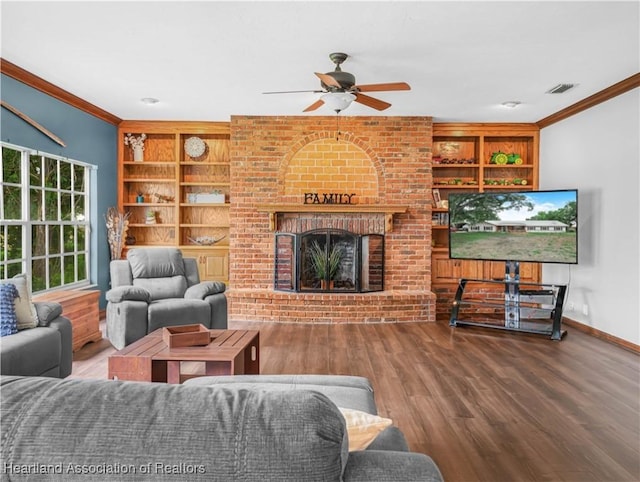 1494 Wilde St, Avon Park, FL 33825 - living room featuring crown molding, built in shelves, a ceiling fan, wood finished floors, and a brick fireplace