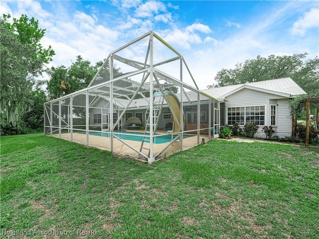 1494 Wilde St, Avon Park, FL 33825 - back of house with an outdoor pool, a yard, a patio, glass enclosure, and a metal roof