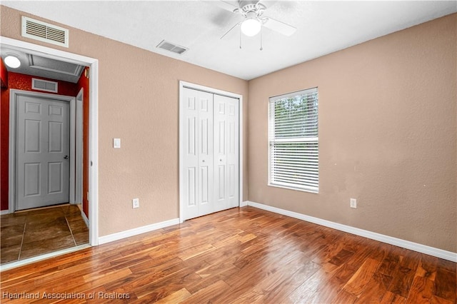 7343 Cortez Blvd, Sebring, FL 33872 - unfurnished bedroom with wood finished floors, a closet, baseboards, a ceiling fan, and a textured wall