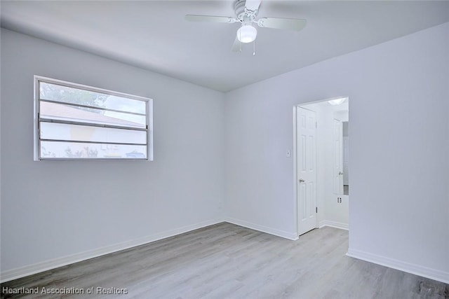 spare room featuring baseboards, ceiling fan, and wood finished floors