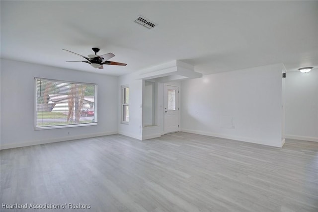 unfurnished living room featuring visible vents, light wood finished floors, ceiling fan, and baseboards