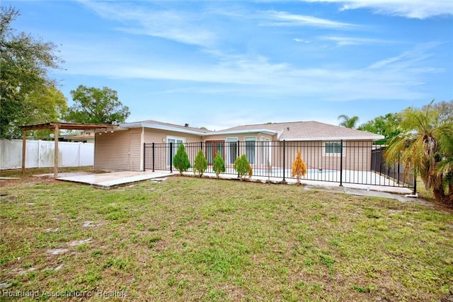 rear view of property featuring a patio, a fenced backyard, a yard, and a pool