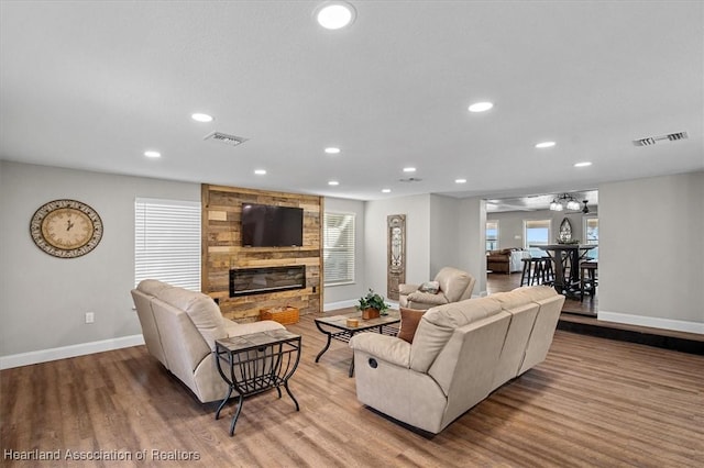 living room with a large fireplace and light hardwood / wood-style flooring