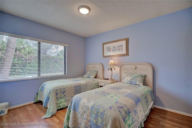 bedroom with hardwood / wood-style floors and a textured ceiling