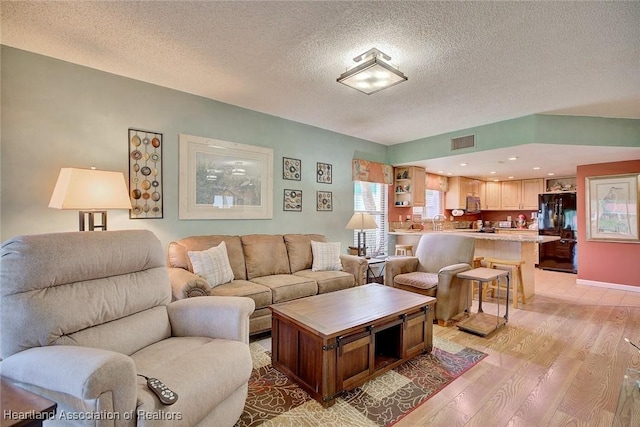 living room featuring light hardwood / wood-style floors and a textured ceiling