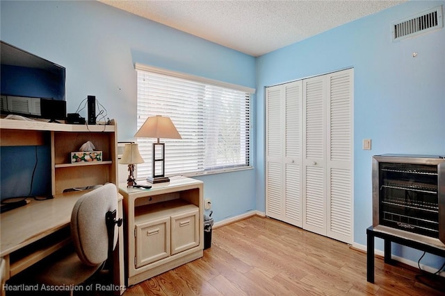 office space featuring a textured ceiling and light hardwood / wood-style flooring