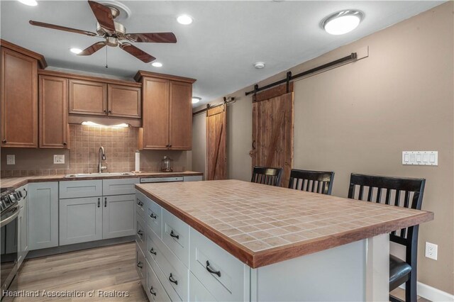 kitchen featuring a kitchen bar, a barn door, a kitchen island, and sink