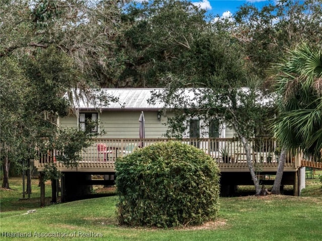 rear view of property featuring a deck and a lawn