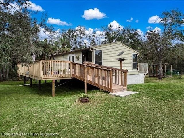 back of property with a yard and a wooden deck