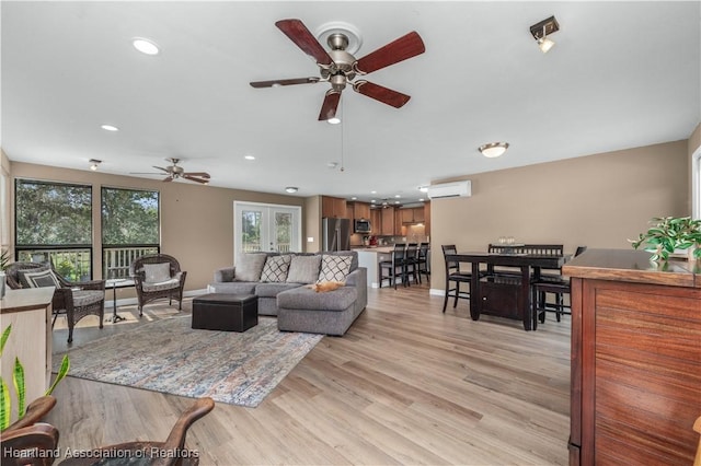 living room with a wall unit AC, ceiling fan, french doors, and light hardwood / wood-style floors