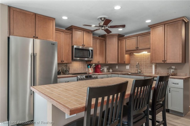 kitchen featuring a center island, a kitchen bar, sink, and appliances with stainless steel finishes