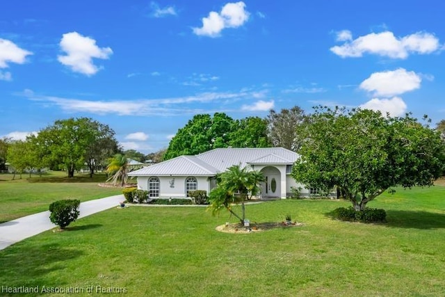 single story home featuring driveway, metal roof, and a front yard