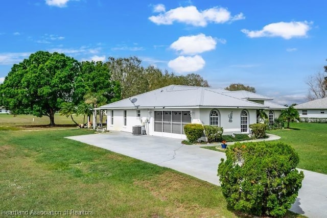 ranch-style house with concrete driveway, a front lawn, stucco siding, and central air condition unit