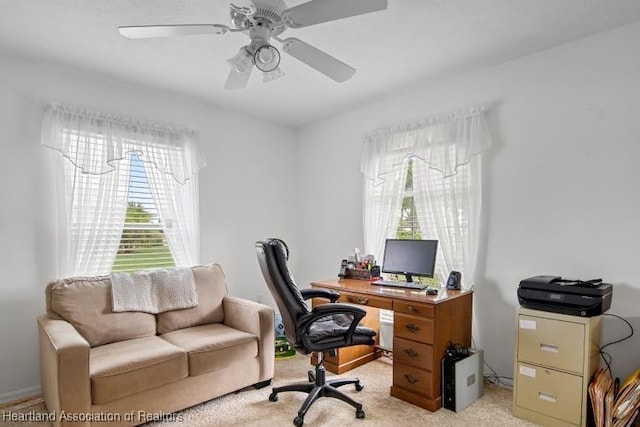 office space featuring light carpet and ceiling fan